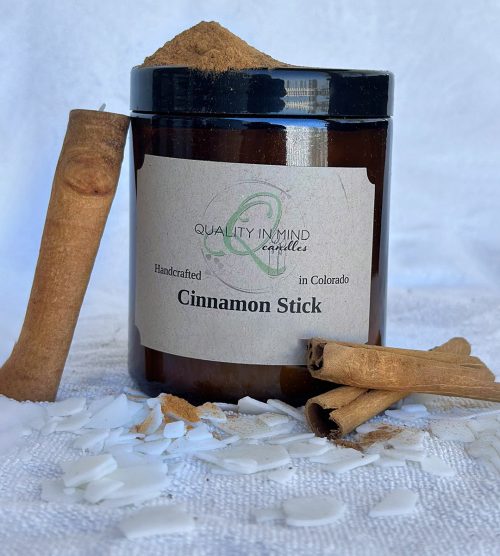 Cinnamon candle displayed with cinnamon sticks