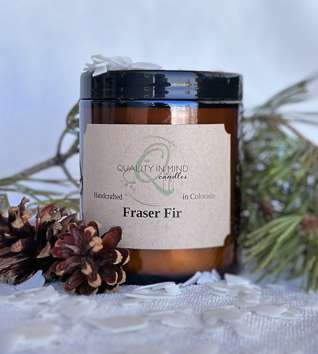 Fraser Fir Candle displayed with pinecones and fir branch