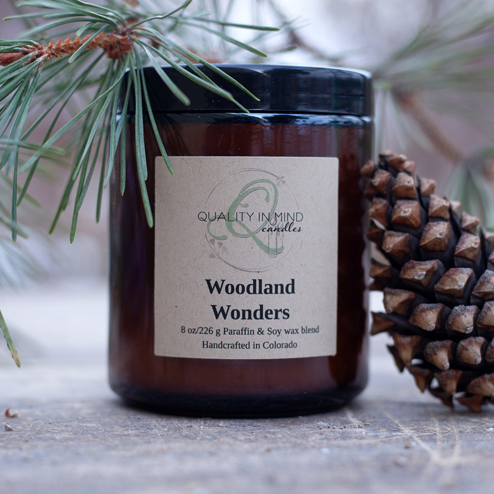 Woodland Wonders candle decorated with pine cone and pine tree